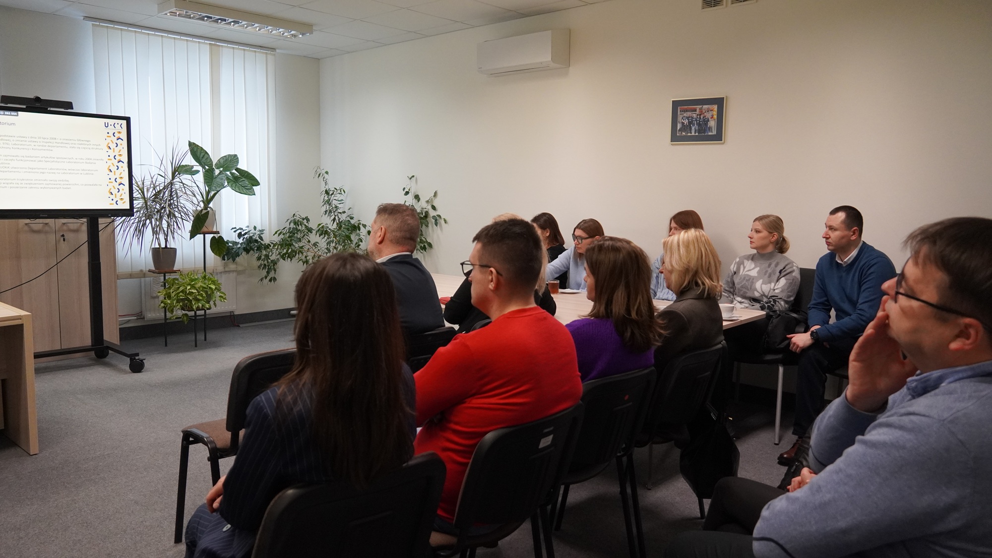 Fragment sali szkoleniowej, na pierwszym planie słuchacze, przed nimi inteligentna tablica projekcyjna